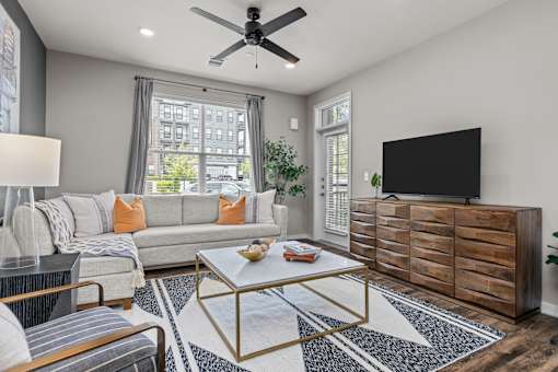 A living room with a grey couch, a coffee table, and a flat screen TV.