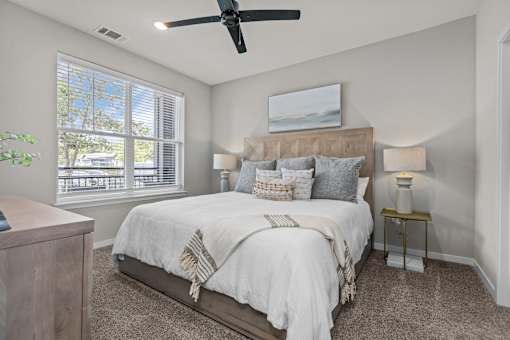 A bedroom with a large bed and a ceiling fan.
