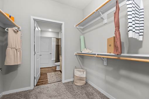 A small, clean, and organized bedroom with a closet and a mirror.