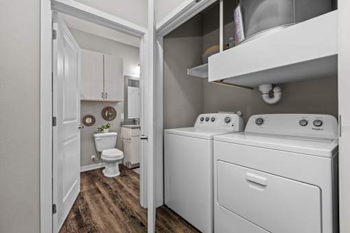 A white laundry room with a washer and dryer.