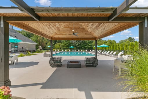 a patio with tables and umbrellas and a pool at The Austin Apartment Homes, New Jersey