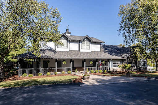 A house with a grey roof and white walls with a black fence in front.