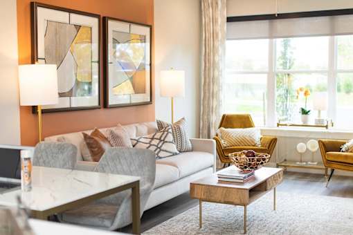 A modern living room with a grey couch, a coffee table, and two lamps.