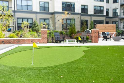 A small putting green in front of a building.