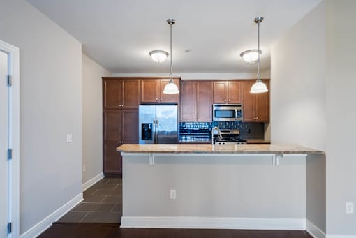 A kitchen with a wooden cabinet and a granite countertop. at Pennsauken Golf Course Villas, PENNSAUKEN, NJ, 08109
