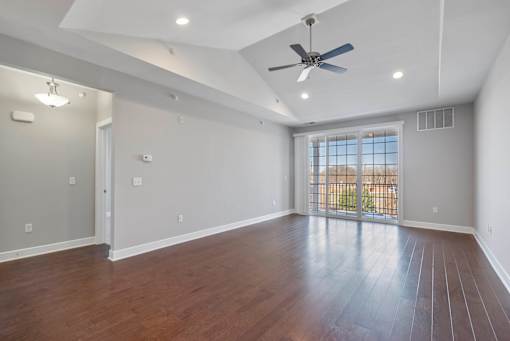 A spacious room with a ceiling fan and wooden flooring. at Pennsauken Golf Course Villas, PENNSAUKEN