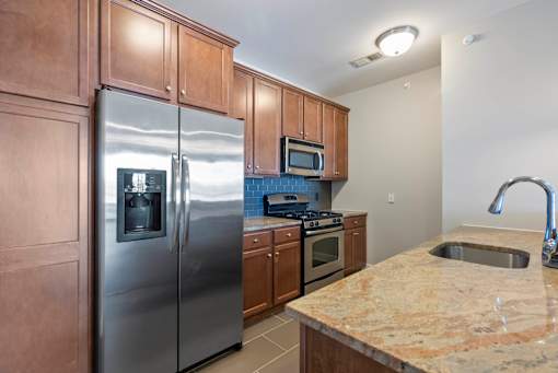 A kitchen with a granite counter top and stainless steel appliances. at Pennsauken Golf Course Villas, PENNSAUKEN, New Jersey