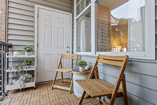 Two wooden chairs are placed on a porch. at Merion Riverwalk Apartment Homes, Shelton, 06484