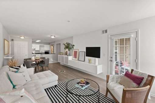 A living room with a white couch and a black and white striped rug.