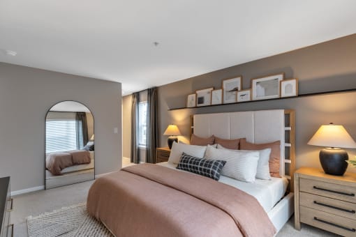 a bedroom with a bed and a mirror at The Austin Apartment Homes, New Jersey, 08096