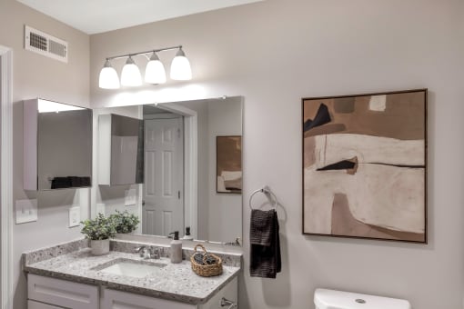 a bathroom with a sink and mirrors and a mirror on the wall at The Austin Apartment Homes, New Jersey