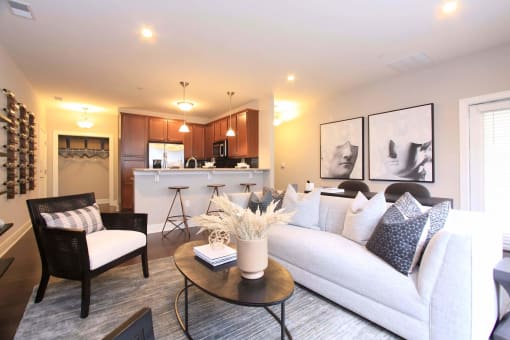 A living room with a white couch and a table with a vase of flowers on it  at Barclay Glen Apartments, New Jersey