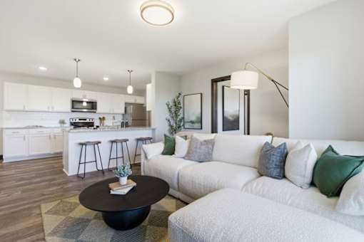 A modern living room with a white couch and a black coffee table.