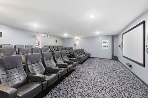 A row of grey seats in a room with a carpeted floor.