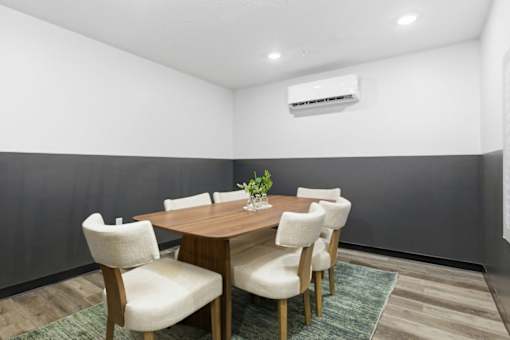 A dining room with a table and chairs.