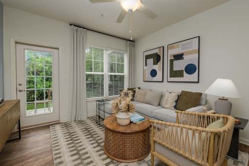A living room with a couch, a coffee table, and a ceiling fan.