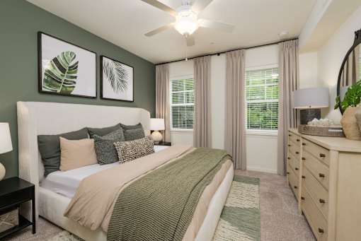 A bedroom with a bed, nightstand, and a ceiling fan.