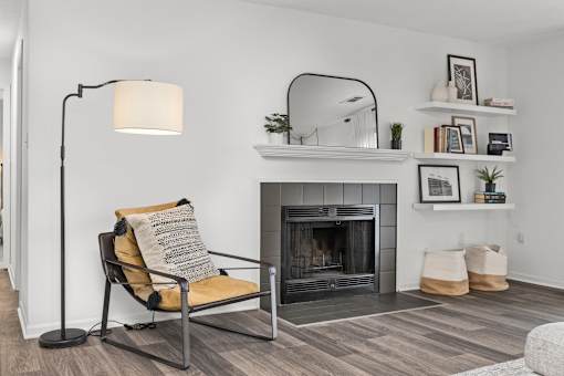 A living room with a chair, a fireplace, and a floor lamp. at Eagle Ridge Apartments, Monroeville, PA, 15146