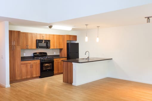 an empty kitchen with wooden cabinets and black appliances at Merion Stratford Apartment Homes, Stratford, CT