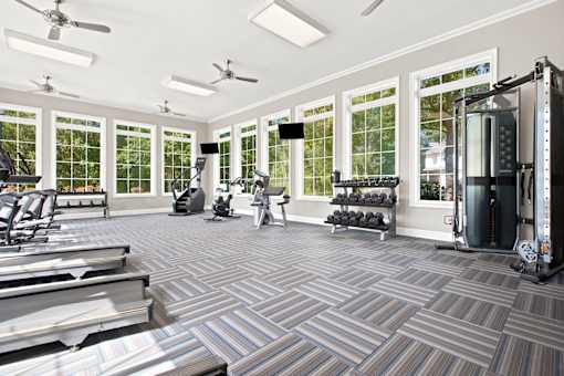 A gym with treadmills, weights, and exercise equipment.
