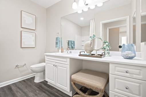 A bathroom with a white vanity and a white toilet.