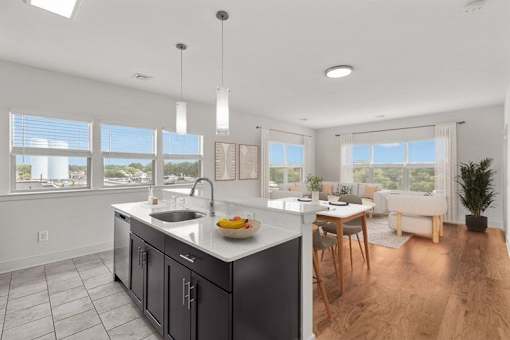 A modern kitchen with a large island and a dining area.