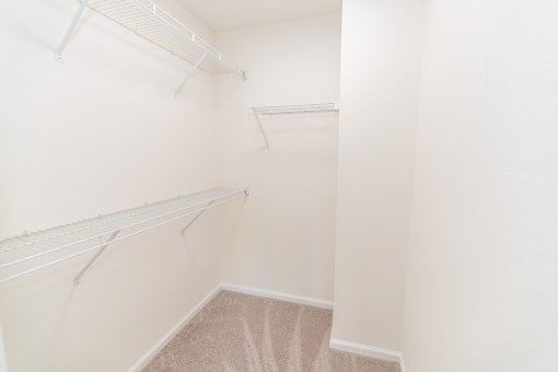 a spacious closet with white walls and shelves and hanging racks at Merion Milford Apartment Homes, Connecticut, 06460