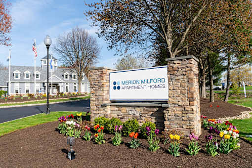 A sign for Merion Milford Apartment Homes is in front of a building.