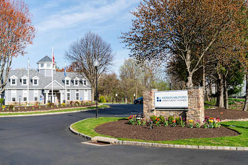 A sign for Merion Milford Apartment Homes is in front of a building.