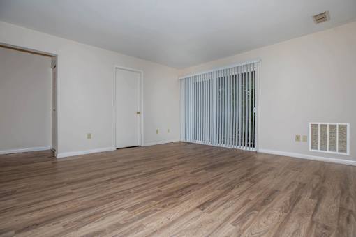 A room with wooden flooring and white walls.