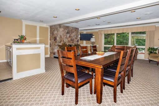 A dining room with a table and chairs.