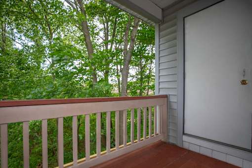 A white door is on the right side of a porch.