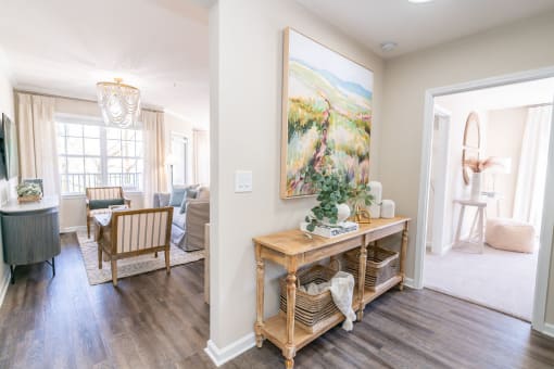 a living room with a table and a painting on the wall at The Ledges Apartment Homes, Groton, CT, 06340