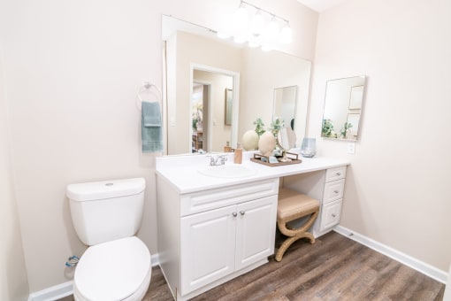 a white bathroom with a toilet and a sink at The Ledges Apartment Homes, Groton, CT, 06340