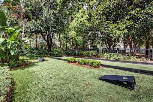 A black object is on the grass in a well kept garden.
