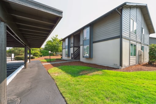 a view of the outside of the building with a paved walkway and grassy area