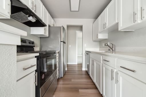 a kitchen with white cabinets and stainless steel appliances