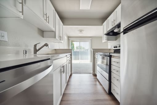 a kitchen with white cabinets and stainless steel appliances