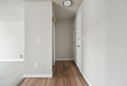 a hallway with hardwood floors and white walls