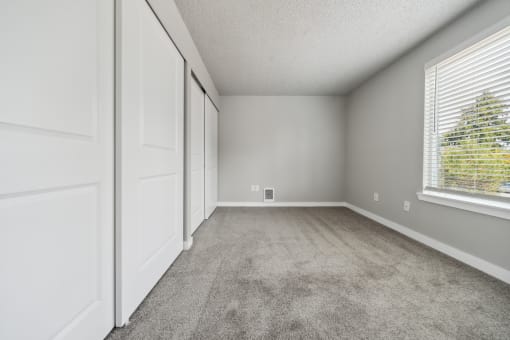 a bedroom with two closets and a window