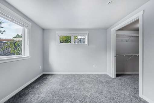 an empty room with a closet and a window