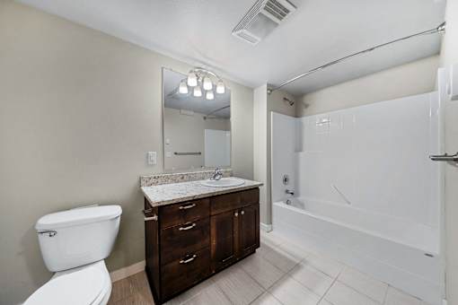 a bathroom with a toilet sink and shower and a mirror