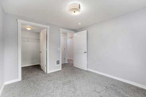 a bedroom with white walls and white doors and a carpeted floor