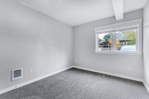 an empty room with carpet and a window