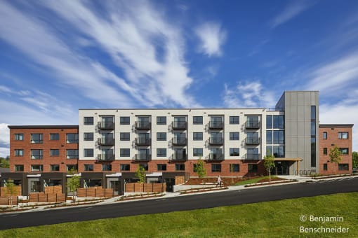 a rendering of an apartment complex with a blue sky in the background