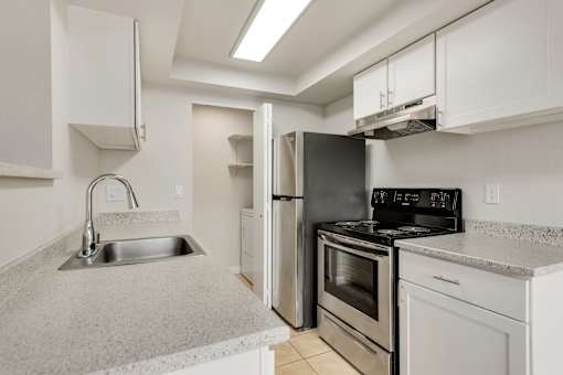 A kitchen with a sink, stove, and refrigerator.