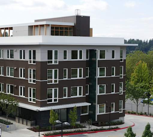 A modern multi-story building with a mix of brown and white exterior.