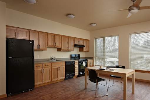 A kitchen with black appliances and wooden cabinets.