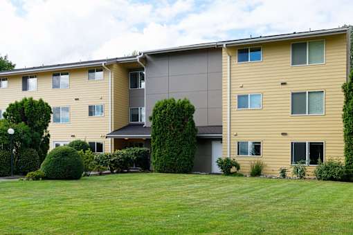 A large building with a green lawn in front.