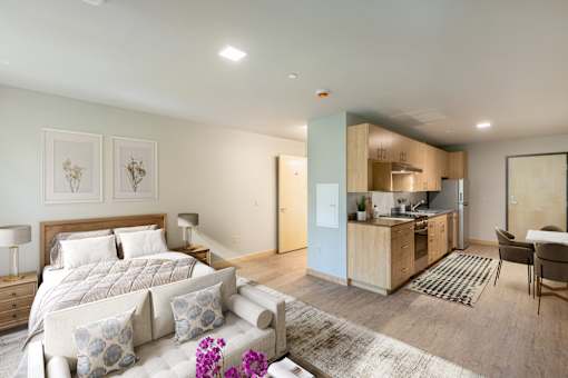 A bedroom with a large bed and a couch with pillows.